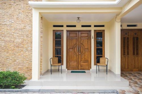 a front door of a house with two chairs at RedDoorz Syariah near Grand Kota Bintang in Bekasi