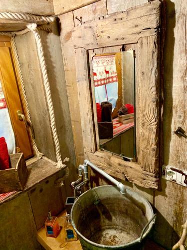a dirty bathroom with a sink and a mirror at ALLA STALLA Suite & Chalet in Piazzatorre