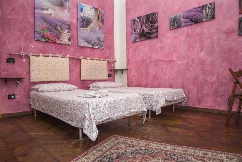 two beds in a room with pink walls at A Casa Fachin Room & Breakfast in Bologna