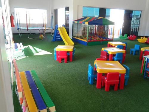 una clase con mesas y sillas coloridas y un parque infantil en Apartamento Lacqua Di Roma, en Caldas Novas