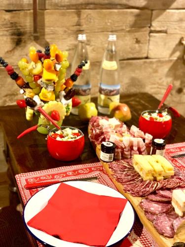 a table topped with cheese and meats and bottles of wine at ALLA STALLA Suite & Chalet in Piazzatorre