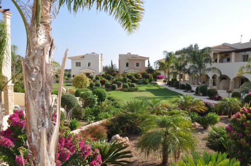 a view of a garden with palm trees and flowers at 2 Bed, 2 Bath Apartment In Mandria in Mandria