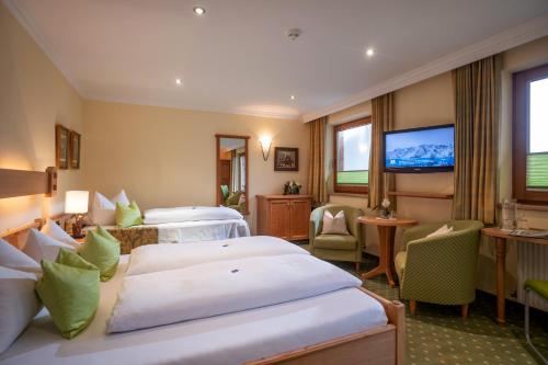a hotel room with two beds and a flat screen tv at Hotel Garni Erler in Mayrhofen