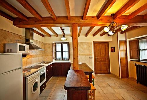 a kitchen with a white refrigerator and a stove at La Indiana in Poo de Cabrales