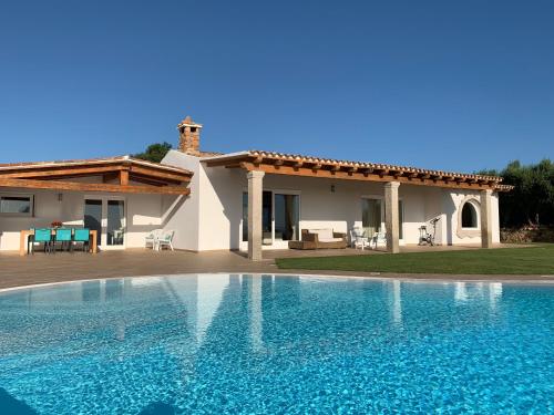 una gran piscina frente a una casa en VillaLuxx, en Porto San Paolo