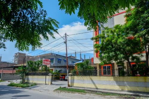 a street in a city with buildings and trees at RedDoorz near Millenium Waterpark Palu in Palu