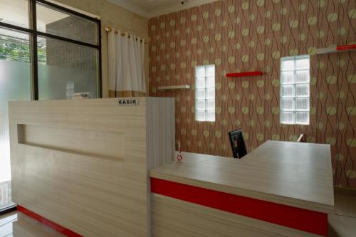 un bureau avec une réception dans une chambre dans l'établissement RedDoorz near Millenium Waterpark Palu, à Palu