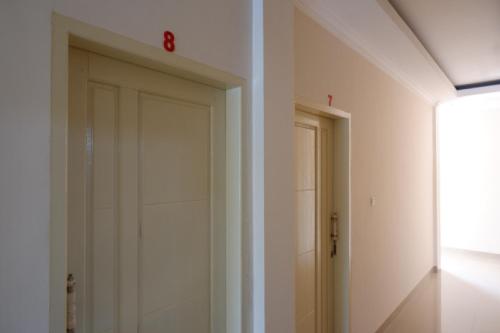 a door in a room with a clock on the wall at RedDoorz near Millenium Waterpark Palu in Palu