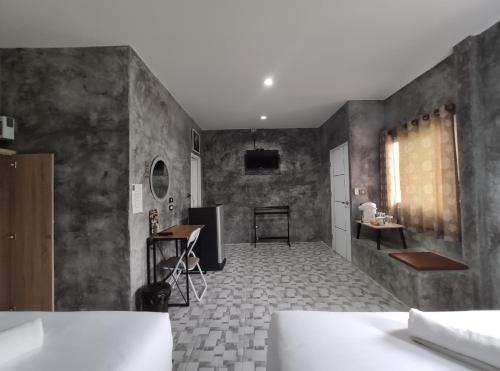 a room with concrete walls and a kitchen with a table at 4 Corner Khaoyai in Mu Si