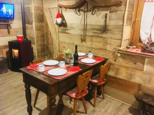 a wooden table with plates and a bottle of wine at ALLA STALLA Suite & Chalet in Piazzatorre