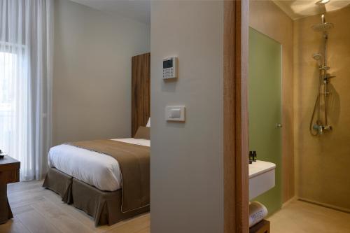 ein Hotelzimmer mit einem Bett und einem Bad in der Unterkunft Minaret Suites and Apartments in Chania