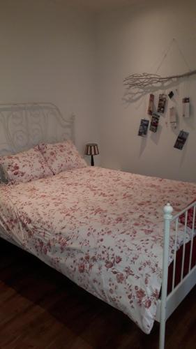a bedroom with a bed with a floral bedspread at B & B De Gouwe Plek in Hoogwoud
