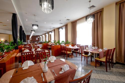 um restaurante com mesas e cadeiras de madeira e janelas em Hotel 500 em Tarnowo Podgórne