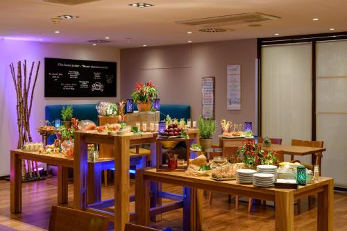 a dining room with tables with food on them at Mercure Hotel Köln West in Cologne