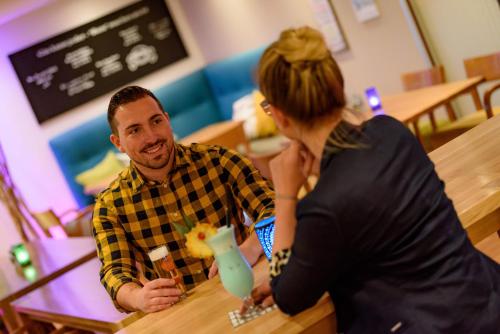 a man and a woman sitting at a table at Mercure Hotel Köln West in Cologne
