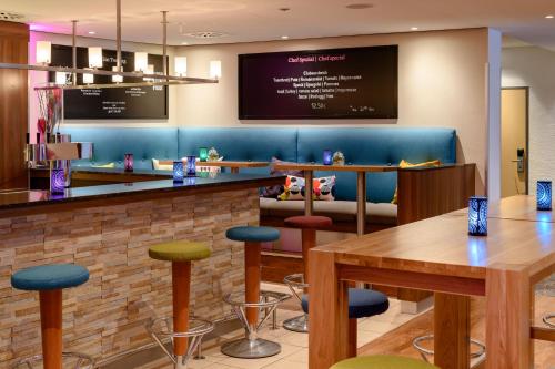 a bar in a restaurant with tables and stools at Mercure Hotel Köln West in Cologne
