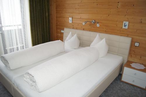 ナウダースにあるAppartment Spoettlのベッドルーム1室(白い枕2つ付)