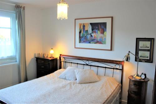 ein Schlafzimmer mit einem Bett und einem Bild an der Wand in der Unterkunft Ferienvermietung Meerlandliebe in Beschendorf