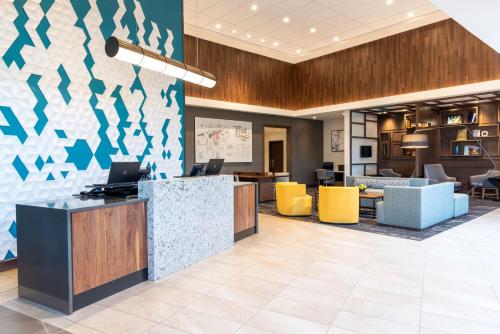 an office lobby with a reception desk and yellow chairs at Hyatt Place Flint/Grand Blanc in Flint