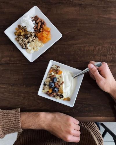 a person eating a bowl of food on a table at Hyatt Place Kansas City/Overland Park/Convention Center in Overland Park