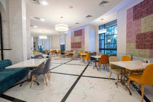 a dining room with tables and chairs at Park Hotel Tskaltubo - Balneo Resort in Tsqaltubo