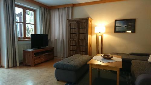 a living room with a couch and a tv at Landhäusl in Weissensee