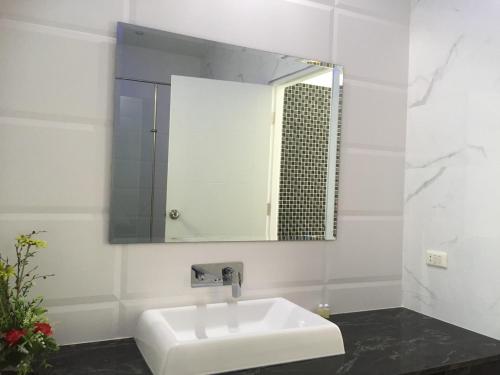 a bathroom with a white sink and a mirror at Majestic Residence pool villa Pattaya in Pattaya South