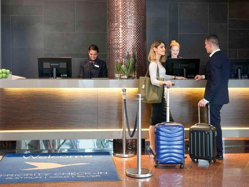 a group of people standing at a counter with luggage at Novotel Sydney Parramatta in Sydney