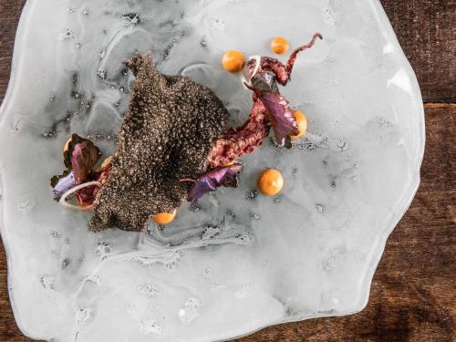 a white plate with food on a table at Santa Teresa Hotel Rio de Janeiro - MGallery Collection in Rio de Janeiro