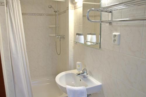 y baño blanco con lavabo y ducha. en Pension Nataliya en Ostrov