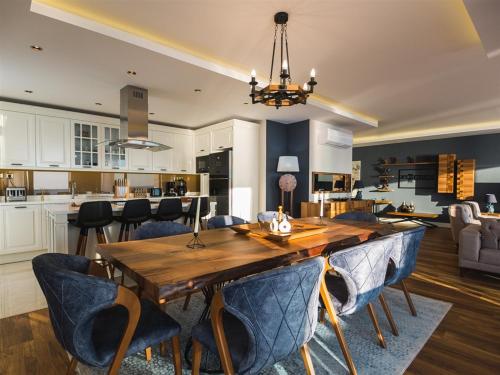 a kitchen and living room with a wooden table and chairs at Arnelya Beach Penthouse 285m2 in Alanya