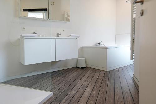 a bathroom with a sink and a mirror at Loft vakantiehuis in Veurne