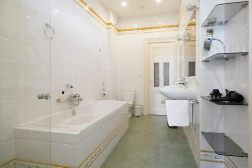 a white bathroom with a tub and a sink at 2 Bedroom 2 Bathroom Canal Apartment in Amsterdam