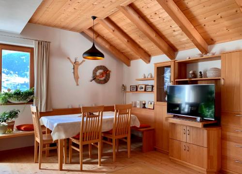 a dining room with a table and a television at Apartment HaNiLe in Sarntal