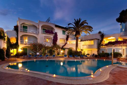 a pool in front of a hotel at night at Hotel Continental Ischia in Ischia