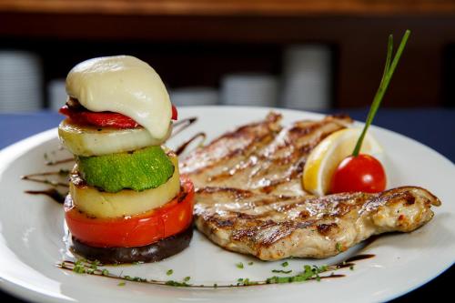 a plate of food with a sandwich and vegetables at Terra Hotel in Bansko
