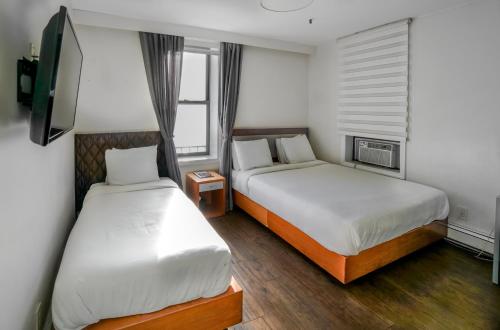 Ein Bett oder Betten in einem Zimmer der Unterkunft Midtown West Hotel