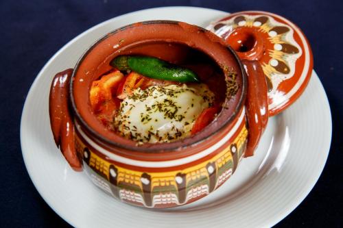 a bowl of food sitting on a white plate at Terra Hotel in Bansko