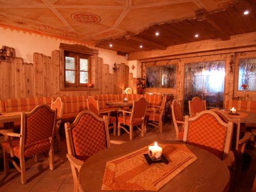 a restaurant with tables and chairs and a candle on a table at Hotel Belvedere in Folgarida
