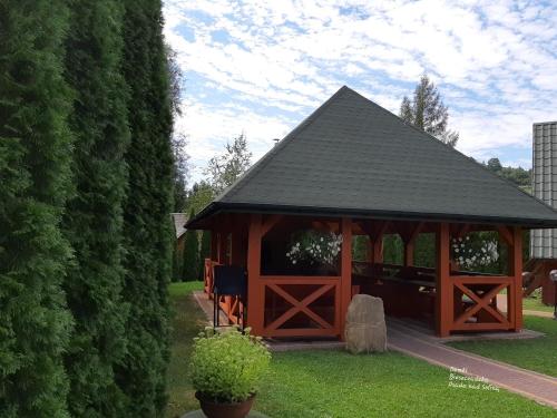 a wooden gazebo with a black roof at Domki nad Soliną - Bieszczadzka Osada 512-823-385 in Solina