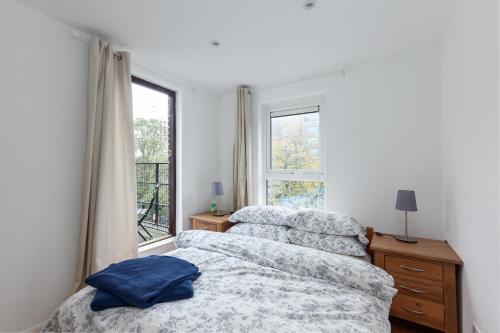 2 camas individuales en un dormitorio con ventana en White City Apartment, en Londres