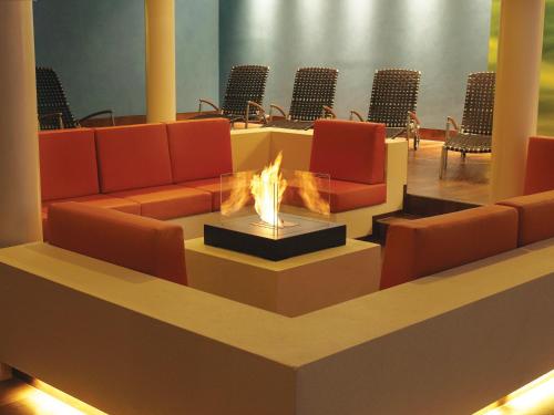 a lobby with orange chairs and a fire pit at Hotel & SPA Sommerfeld - Adults Only in Kremmen