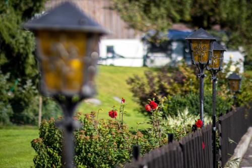 a fence with two street lights next to a garden at Walch's Camping & Landhaus in Braz