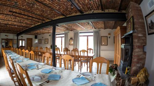 B&B Ferme Château de Laneffe في Laneffe: غرفة طعام مع طاولة طويلة وكراسي