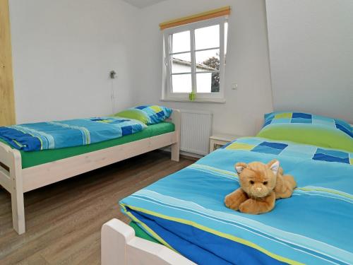 a teddy bear sitting on a bed in a bedroom at Ferienhof Kragholm in Munkbrarup