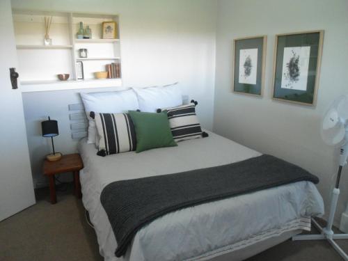 um quarto com uma cama com almofadas verdes e brancas em "La Couronne" em Joanesburgo