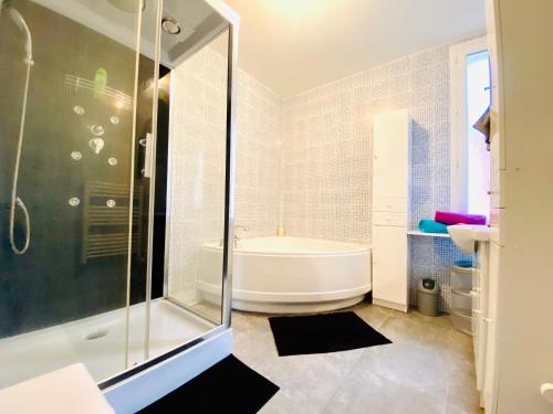 une salle de bain blanche avec une baignoire et une douche dans l'établissement MAGNIFIQUE APPART 102 m2 AU BORD DE L'EAU HYPER CENTRE, à Sète