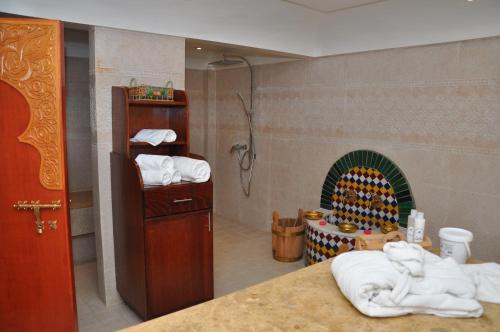 a bathroom with a shower and a fireplace with towels at Across Hotels & Spa in F&egrave;s