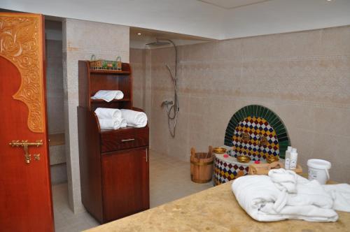 a bathroom with a shower and a fireplace with towels at Across Hotels & Spa in Fès