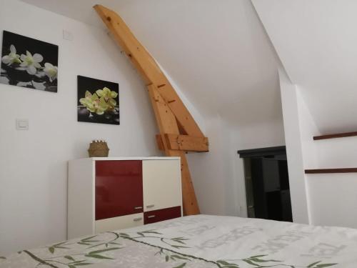1 dormitorio con cama y escalera de madera en Ty bily, en Plaudren